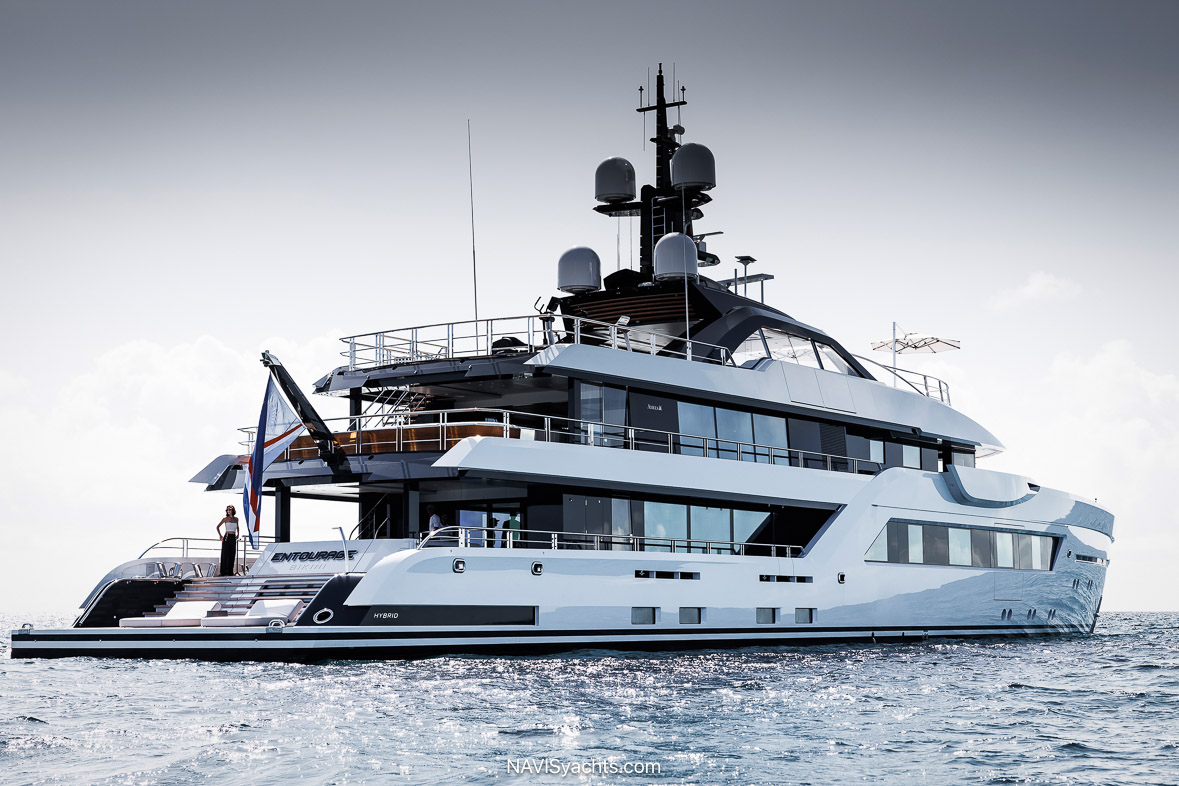 The 60-meter Amels motor yacht Entourage gliding across the water, showcasing the Espen Øino-designed exterior with its strong bow and elongated, continuous windows along the main deck.