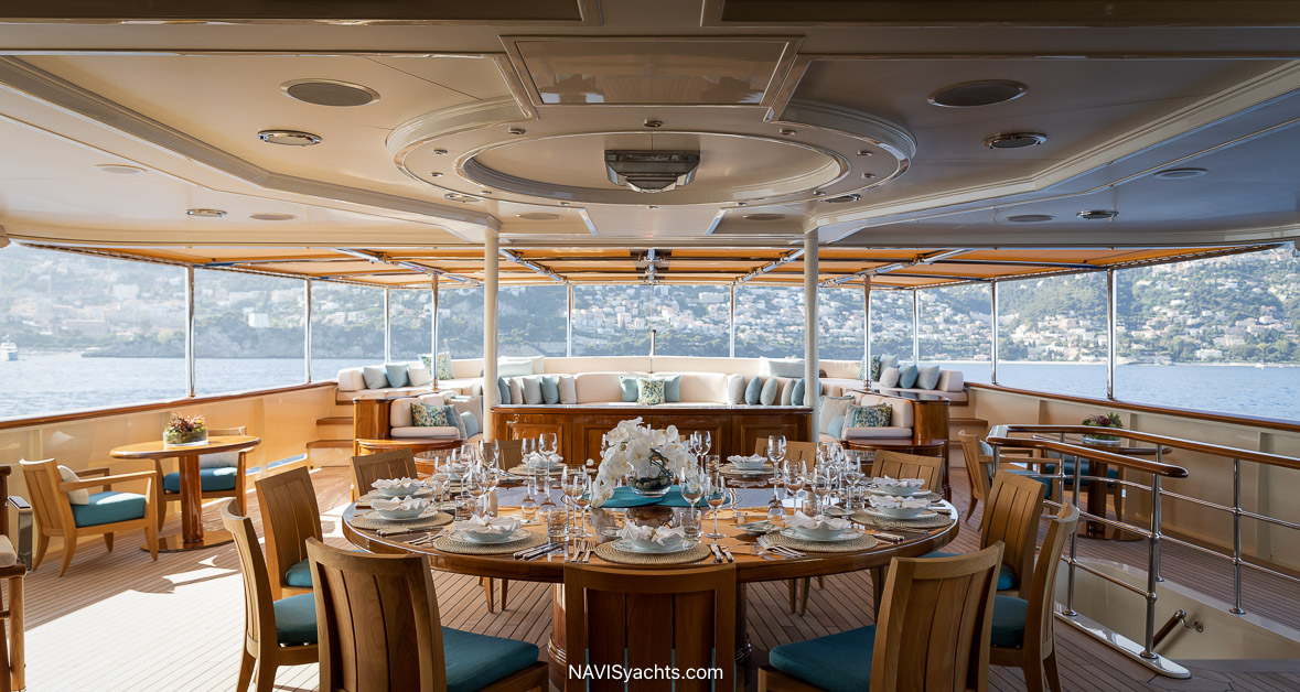 Nero yacht main deck aft lounge and outdoor dining area with curved banquette seating