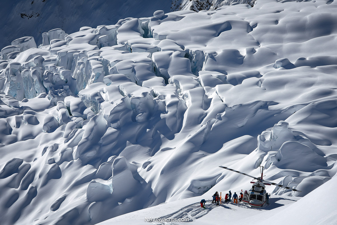 CMH helicopter collecting skiers in remote mountain terrain